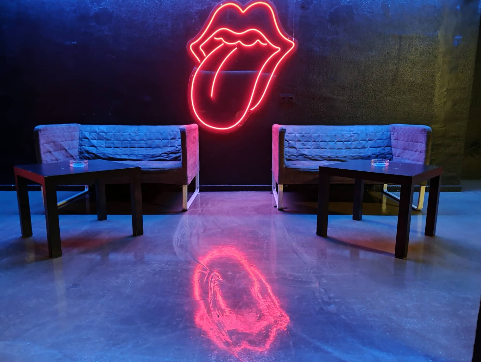 L'insegna al neon dei Rolling Stones illumina l'atrio di un cannabis social club di Barcellona, creando un'atmosfera vibrante e rilassante mentre si fuma cannabis